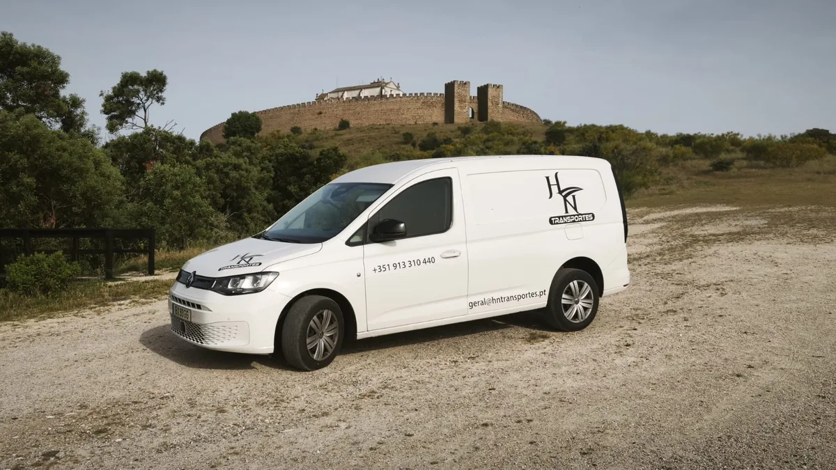 Carrinha da HN Transportes com um castelo no horizonte