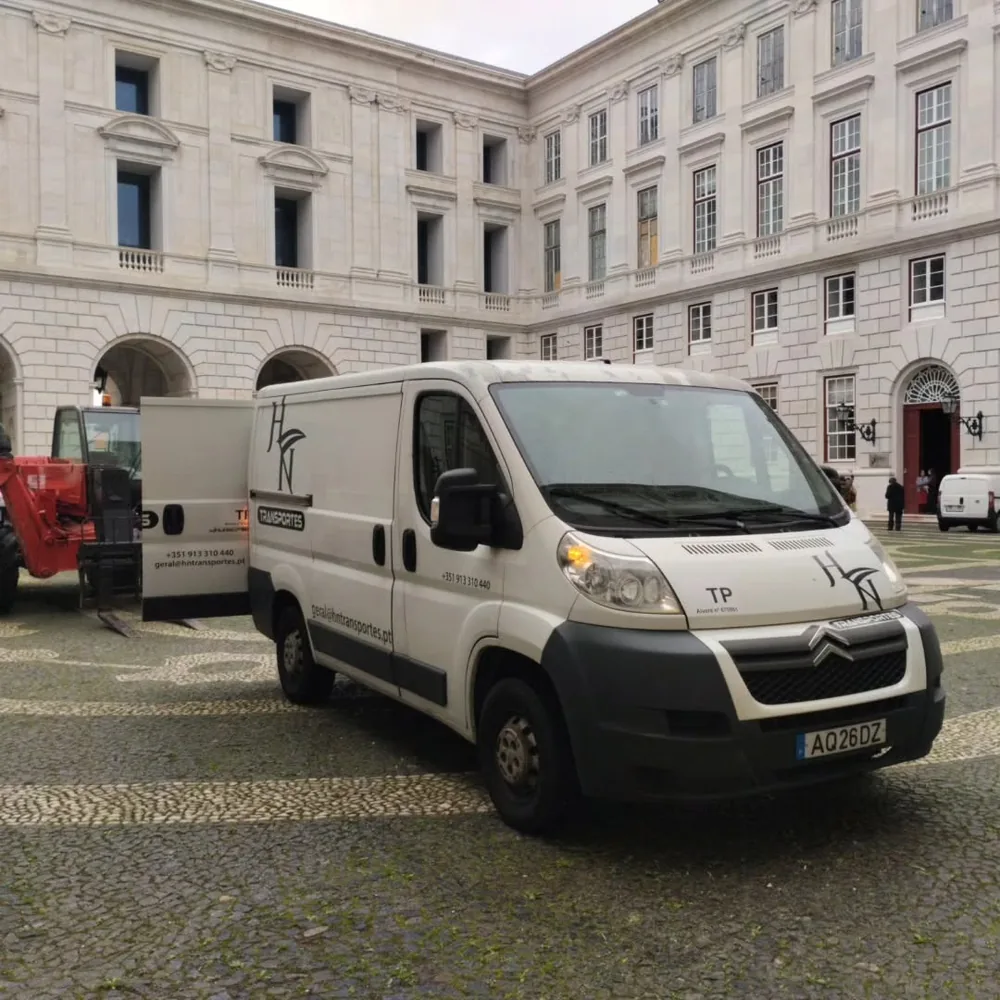 Carrinha da HN Transportes num pátio de edifício histórico